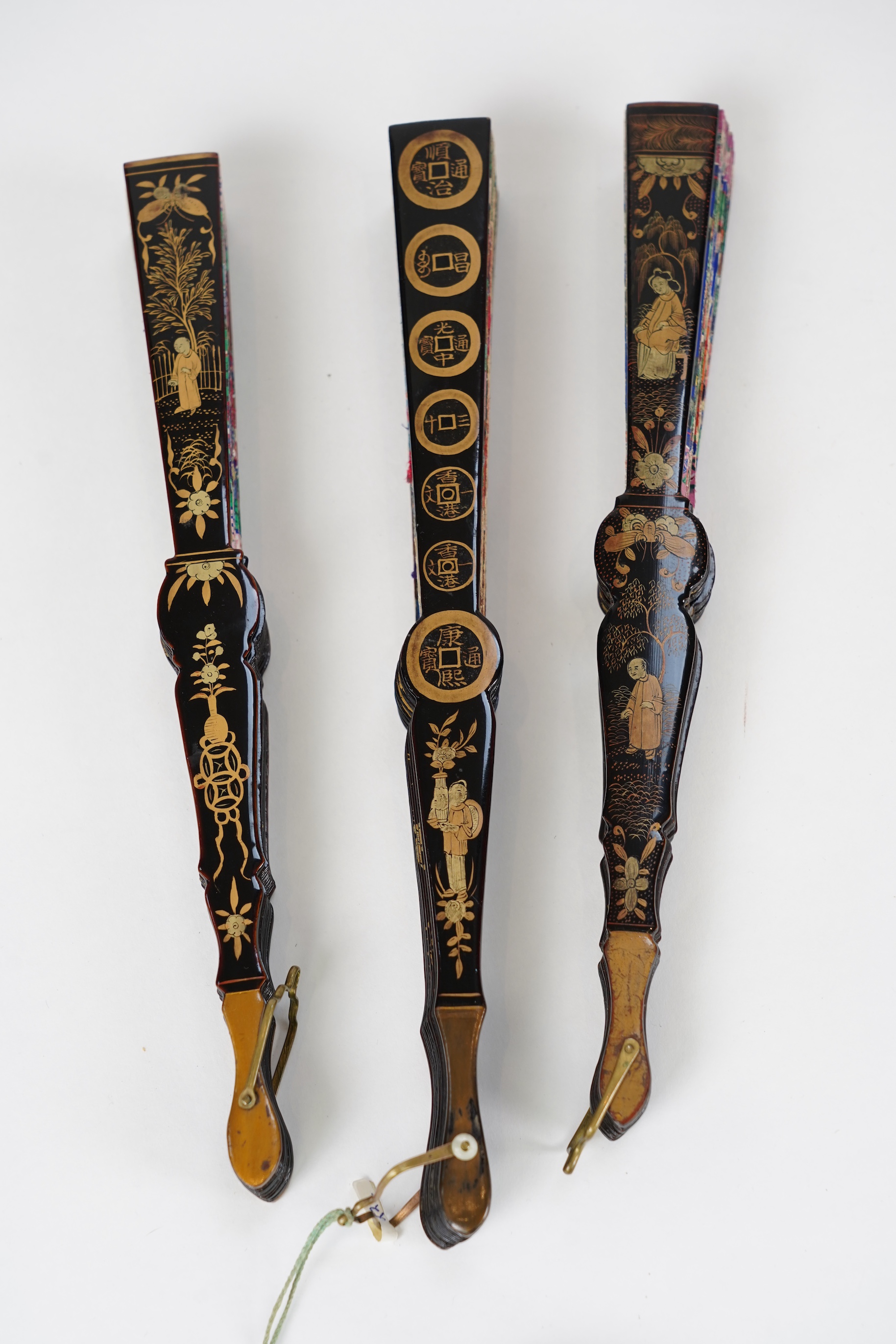 Three Chinese gilt-decorated black lacquer and painted leaf fans, 19th century